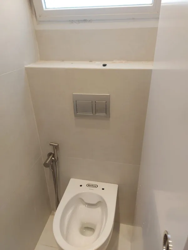 אסלה תלויה עם לחצן הדחה בקיר וברז בידה