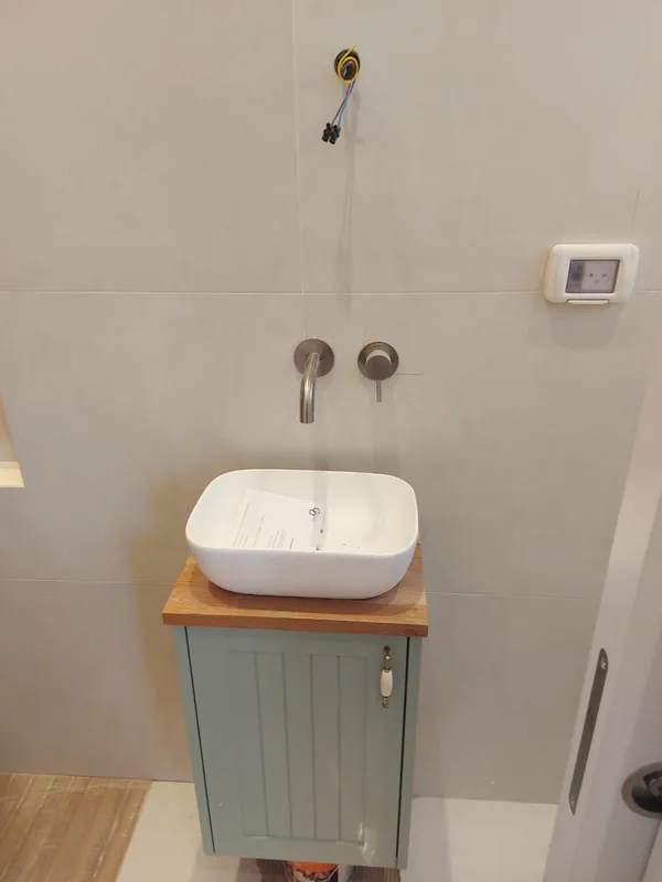 כיור מונח על ארון אמבטיה וברז מהקיר